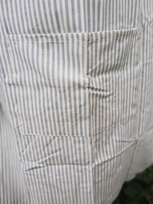 en fin lomme på det lyseblå forklæde
